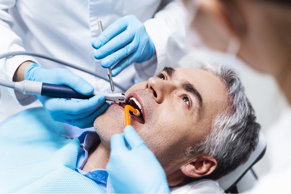Patient is lying in dental chair and being given root cana
